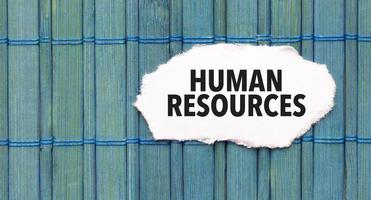 human resources word on torn paper with blue wooden background photo