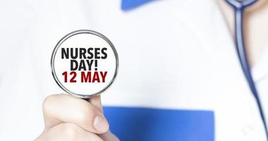 firmar enfermeras día 12 mayo y mano con estetoscopio de médico médico foto