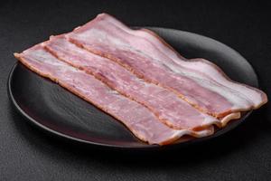 Delicious fresh bacon stripes with spices and salt photo