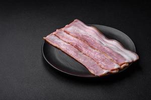 Delicious fresh bacon stripes with spices and salt photo