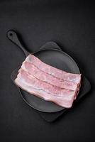 Delicious fresh bacon stripes with spices and salt photo