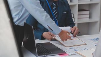 Financial analysts analyze business financial reports on a digital tablet planning investment project during a discussion at a meeting of corporate showing the results of their successful teamwork. video