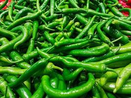 Fresh green pepper in wooden basket at traditional grocery counter, fresh and healthy food idea, organic vegetable, many green peppers, local greengrocer concept photo