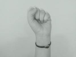 Closeup of left male hand - raised up clenched fist, isolated over white background photo