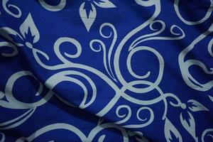 Bright blue background with batik ornaments such as flowers photo