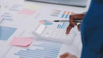 un groupe d'hommes d'affaires confiants pointe vers des graphiques et des graphiques pour analyser les données du marché, le bilan, le compte, le bénéfice net afin de planifier de nouvelles stratégies de vente pour augmenter la capacité de production. video