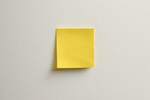 Blank yellow sticker notes on the white wall background. photo