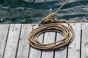 rope coiled on a wooden dock securing a vessel photo
