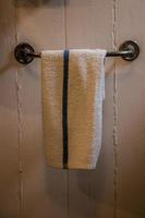 Towel hanging on a bar in a rustic bathroom photo