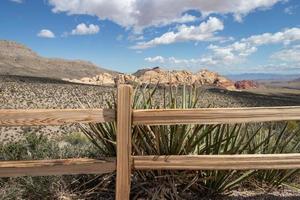 View of the mountains and desert from behind a wood rail fence in Nevada photo