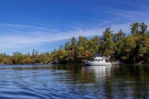 Boat at anchor at Georgian Bay Islands National Park on a sunny autumn day in Canada photo
