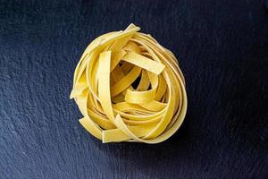 Dry Italian tagliatelle pasta background healthy food photo