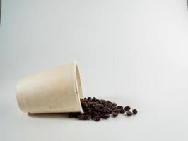 Roasted Arabica coffee beans, ready to make coffee that people like to drink. Placed in a white coffee cup paper on the background. Looks beautiful and appetizing. Drink. photo