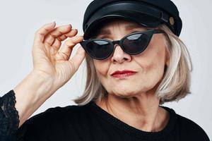 fashionable elderly woman wearing sunglasses posing close-up photo