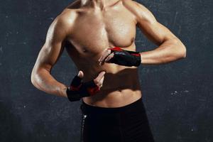 bodybuilder muscle press posing cropped view dark background photo