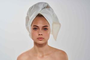 woman with a towel on her head bare shoulders close-up clean skin photo