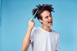 problems with combing hair young guy in t-shirt and combing curls model photo