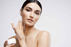 woman with bare shoulders cream jar skin care moisturizing photo
