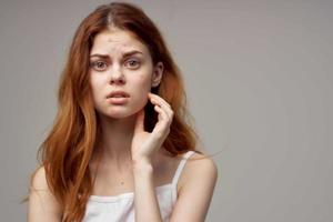 beautiful woman in a white t-shirt pimples on the face isolated background photo