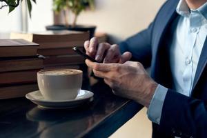 man with a phone in his hands sitting in a cafe leisure work lifestyle businessman photo