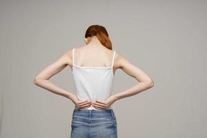 mujer en blanco camiseta espalda dolor salud problemas osteoporosis estudio tratamiento foto