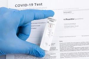 resultado positivo de la prueba mediante el uso de un dispositivo de prueba rápida para covid-19. foto