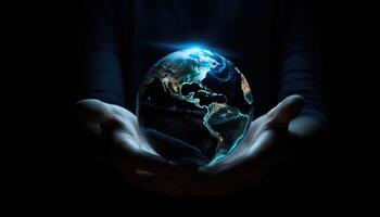 Shiny round world in human hands at night time. Earth Day. Energy saving concept. photo