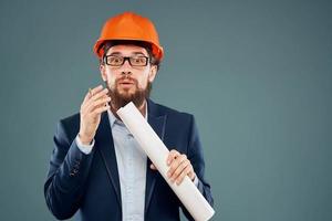 Male engineer wearing a suit in orange paint safety work drawings photo