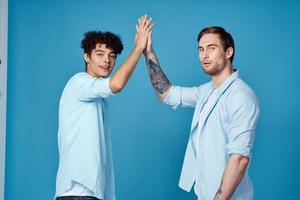 young guys in matching t-shirts and shirts fun greetings blue background friends photo