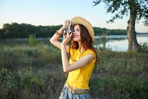 mujer fotógrafo mira dentro el cámara lente sonrisa naturaleza Fresco aire estilo de vida foto