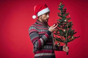 man in christmas clothes christmas tree decoration holiday red background photo
