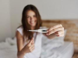 woman showing at the thermometer close-up smile photo