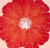 Round piece of grapefruit on a white isolated background, top view photo