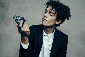 photographer with camera indoors on gray background and jacket curls shirt model photo