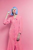 portrait of a woman in blue wig pink dress red lips isolated background photo