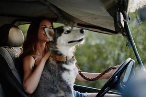 mujer y su fornido perro felizmente de viaje en coche sonrisa con dientes otoño caminar con mascota, viaje con perro amigo foto