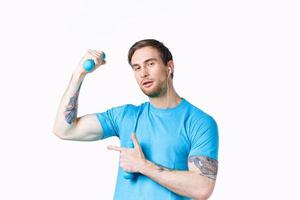 man with inflated arm muscles shows finger to the side and dumbbells bodybuilder fitness photo