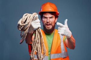 A man in a working uniform with a rope in his hands emotions construction lifestyle photo