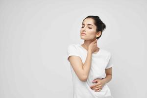 mujer en un blanco camiseta dolor en el cuello salud problemas foto