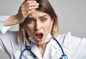 woman doctor in medical mask holding hands near face blue stethoscope cropped view photo