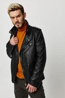 man straightens leather jacket orange sweater pants fashion style photo