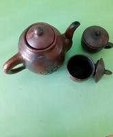 A set of teapots and clay cups isolated on a green background. photo