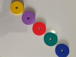 A round colorful wooden toy with a hole in the middle. Educational toy concept. photo