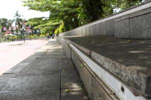 A long concrete bench for seating visitors in a city park. photo