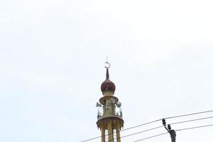 Bogor Indonesia March 2023 The minaret of the mosque against the background of the blue sky. Islamic concept. photo