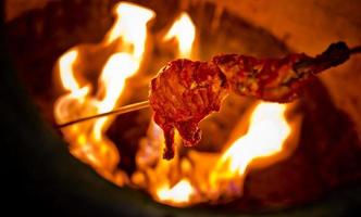 utilizando en un hierro palo es asado pollo en el horno. foto