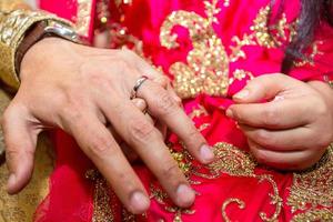 Groom places the wedding ring on the Brides finger at Bangladesh. Close up image. photo