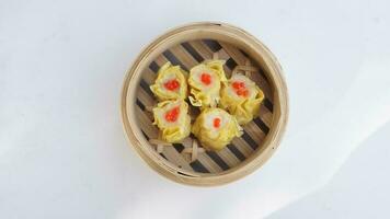 top view Chinese steamed dumplings in bamboo basket on white background photo