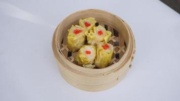 top view Chinese steamed dumplings in bamboo basket on white background photo