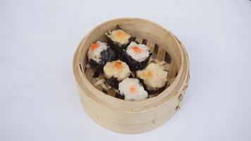 steamed maki rools in bamboo basket on white background photo